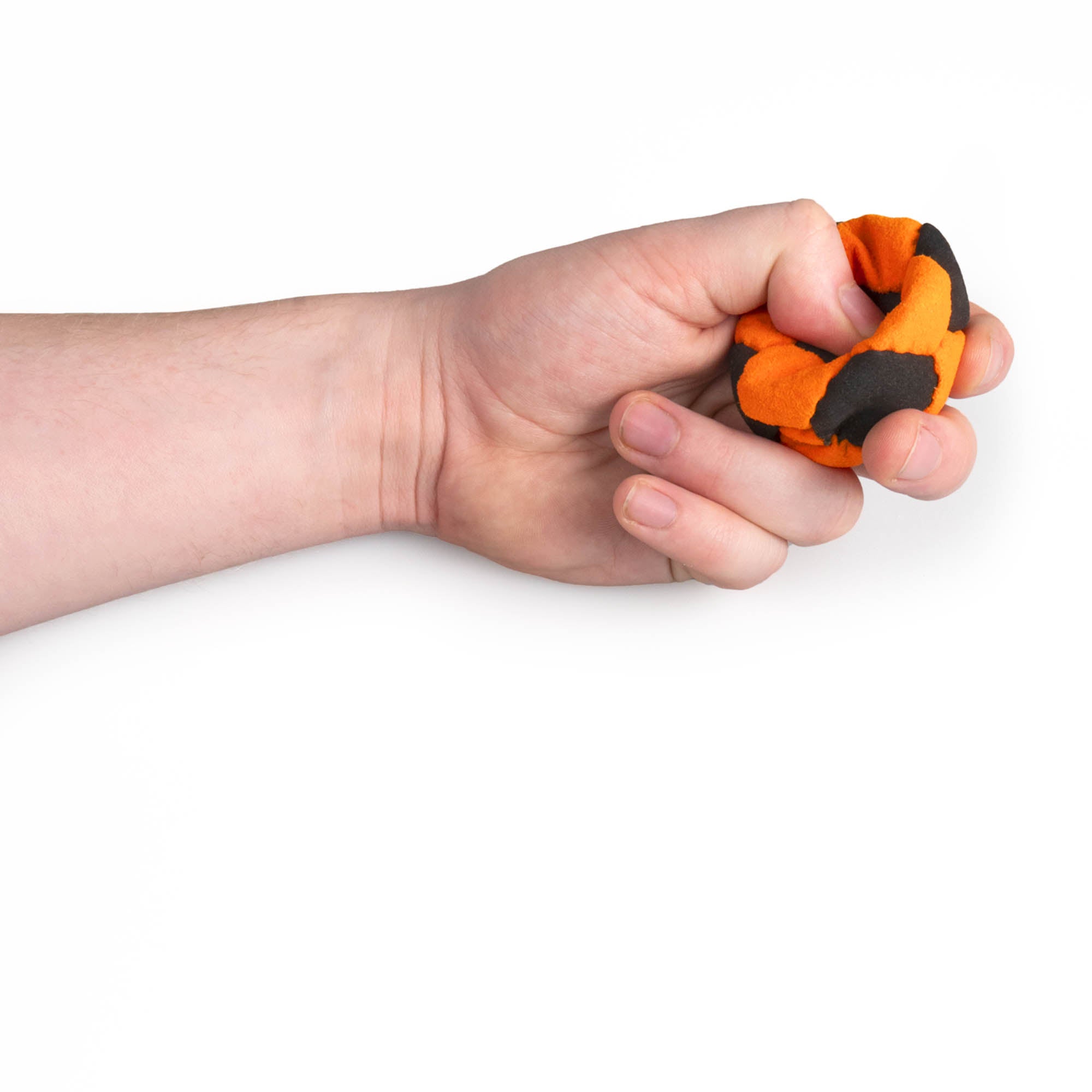 Orange and black hacky sack in hand being squeezed