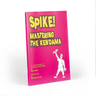 Spike mastering the kendama book at a slight angle with a white background