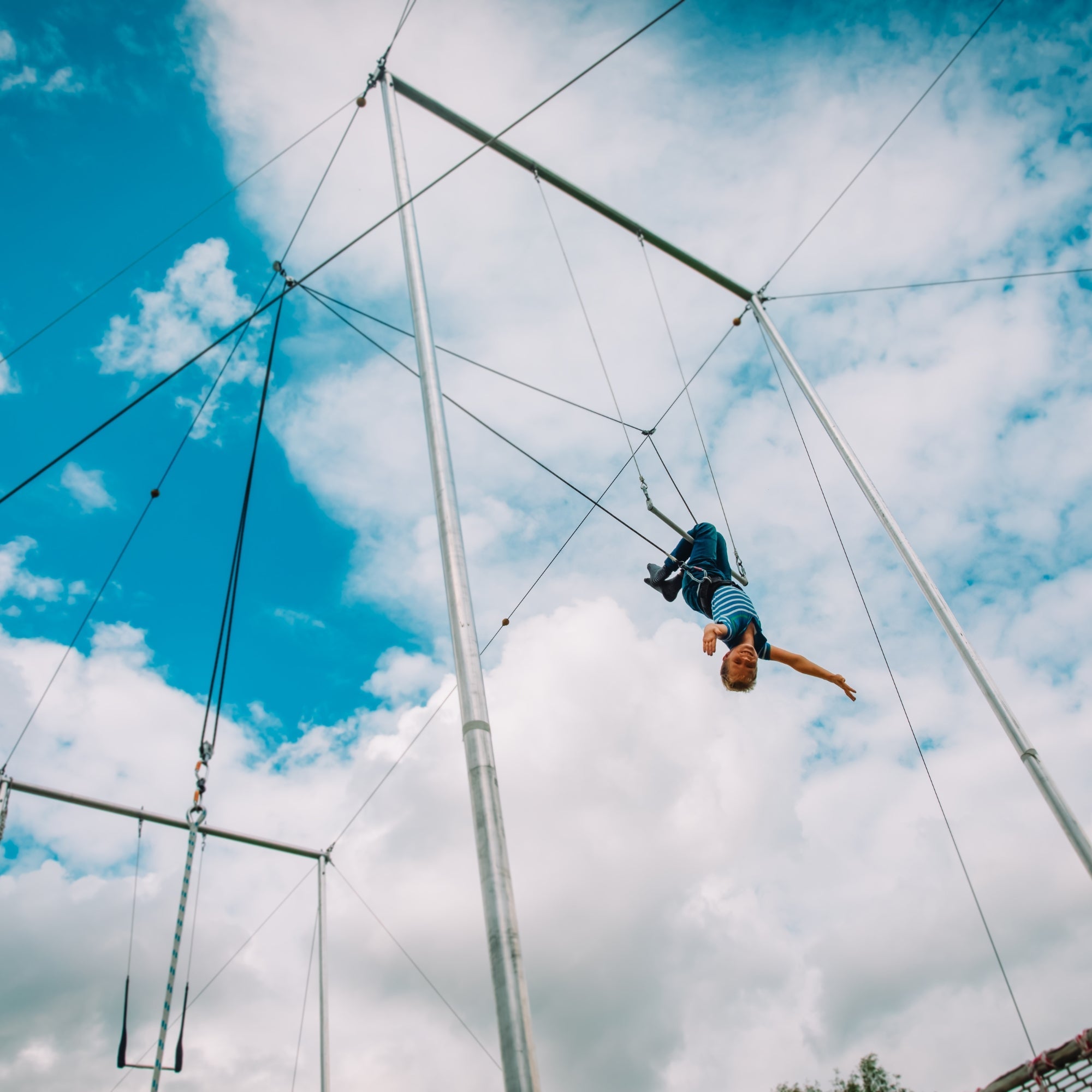 performer on flying trapeze with acro-lunge